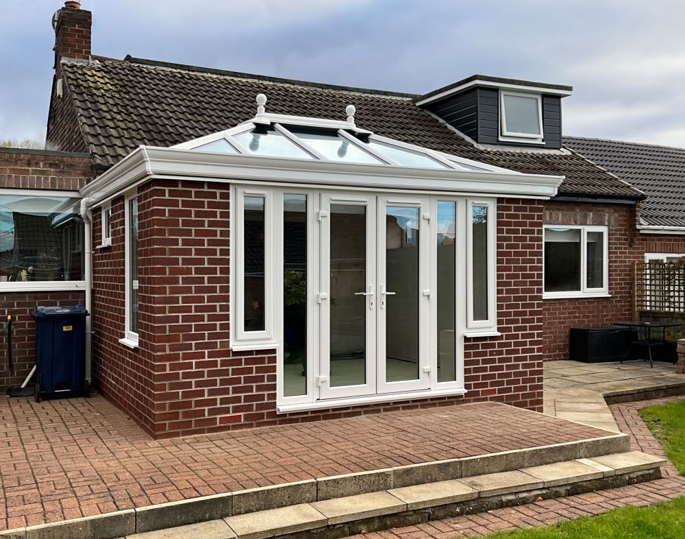 white upvc orangery with white upvc french doors and glass roof