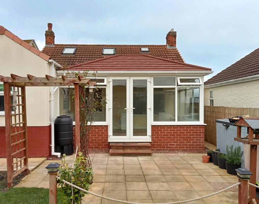 tiled roof conservatory with white upvc bifold doors